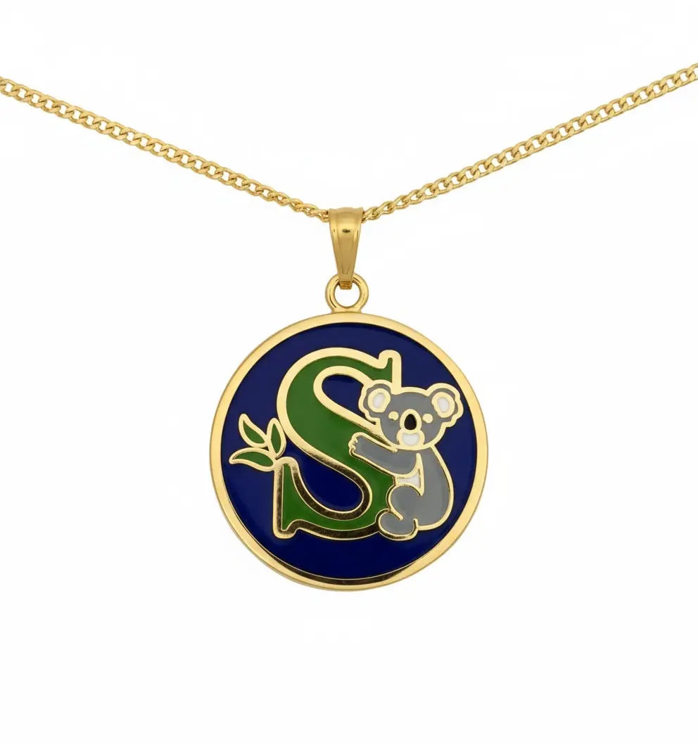 Gold necklace with a pendant featuring a green 'S' and a koala on a blue background.