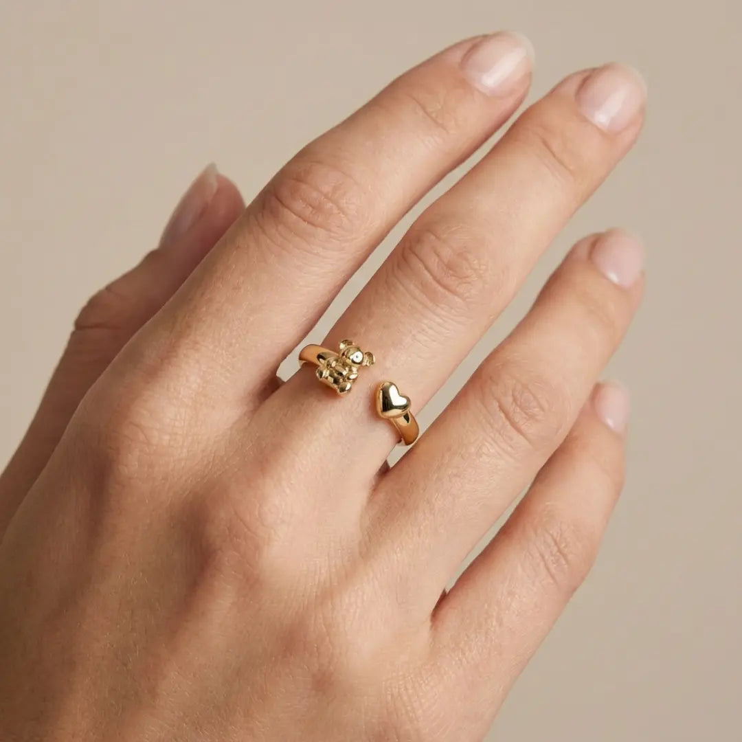 Handmodel wearing 9ct gold ring featuring a koala on a beige background