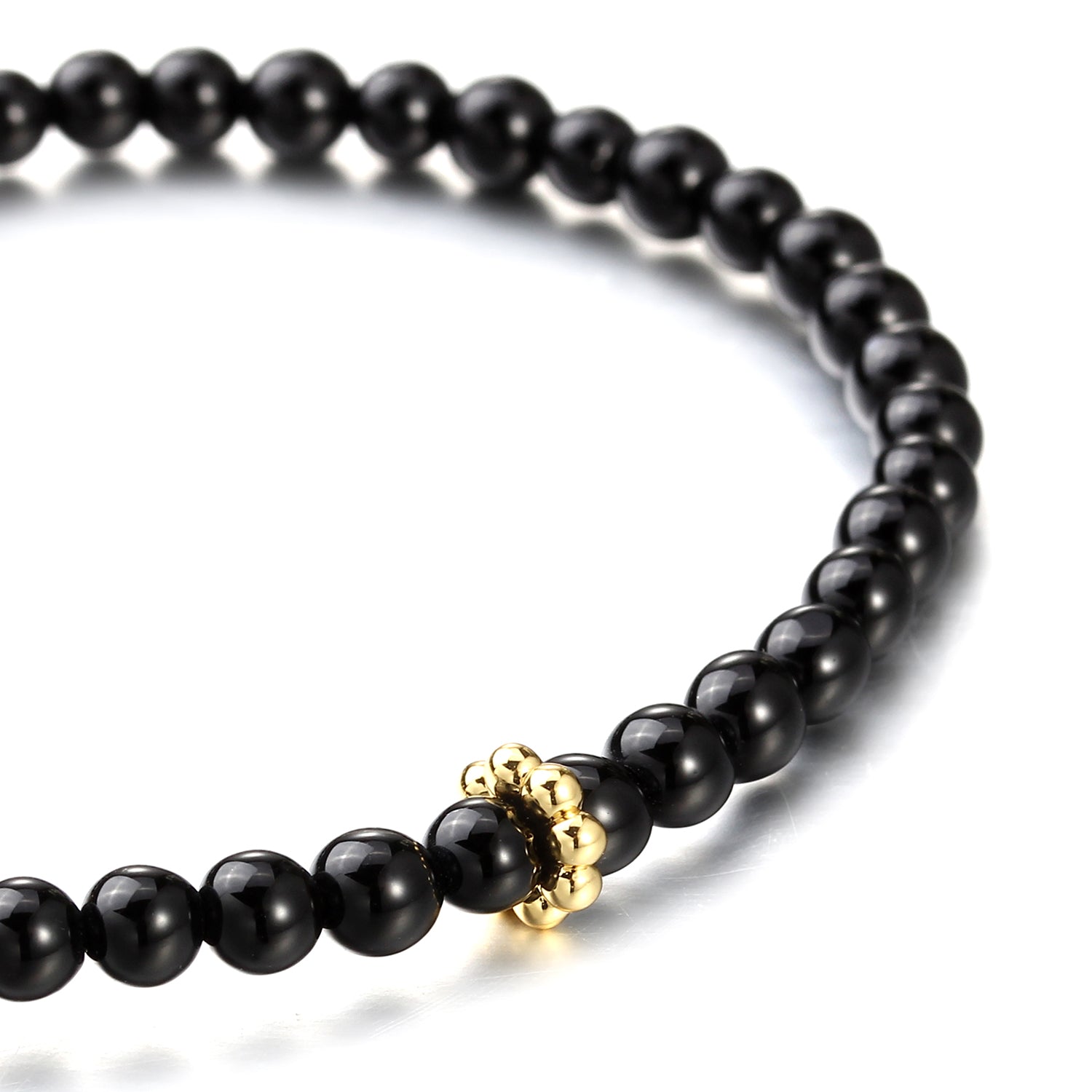 Black beaded bracelet with a gold ring on a white background