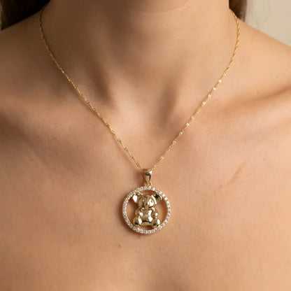 Gold necklace with a Koala CZ circle pendant on a person's neck