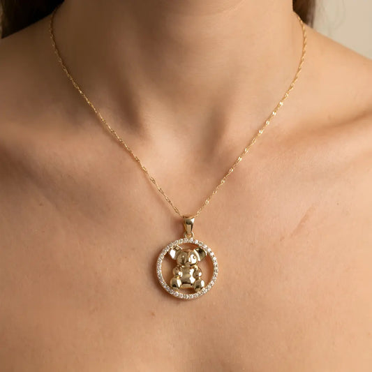 Gold necklace with a Koala CZ circle pendant on a person's neck