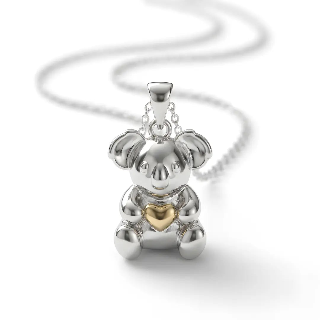 Silver Koala pendant with a gold heart on a white background.