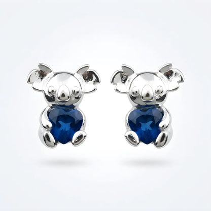 Silver Koala earrings with blue heart cz on a white background