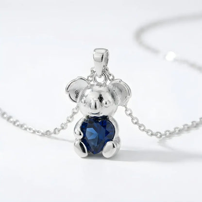 Silver Koala pendant with a sapphire cz heart on a white background